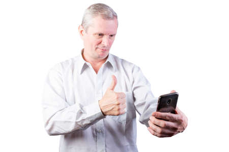 Elderly man wearing shirt shows class sign in smartphone. Isolated on a white background. For any...