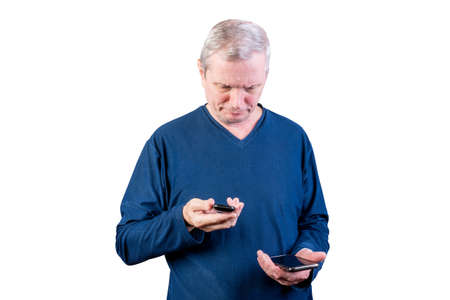 An elderly man chooses between an old telephone and a smartphone. Isolated on a white background....