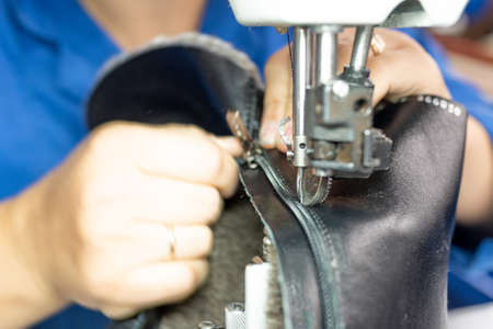 The process of sewing shoes on a sewing machine. Shoe production. For any purpose.