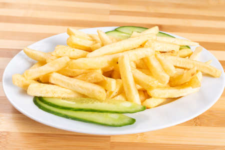 French fries, on a plate, with a cucumber. For any purpose.の写真素材