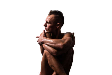 Athletic, tanned man put his hands to his head. With a naked torso. Isolated on a white background. For any purpose.の写真素材