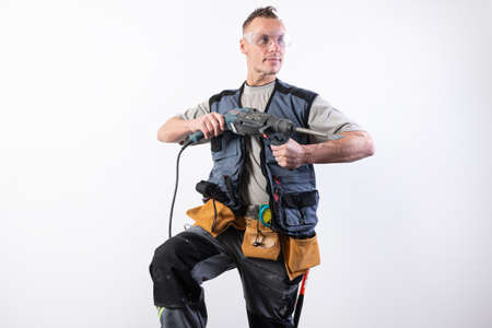 Builder with a drill in his hands, in unloading, aims to the right. For any purpose.の写真素材