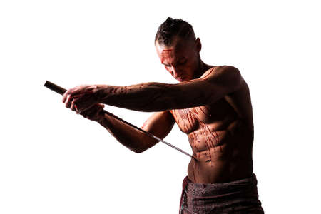 A man with a katana, in blood, makes hara-kiri. Isolated on a white background.の写真素材