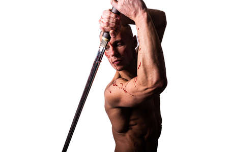 Handsome man with a bare torso and blood. Posing with a sword. Isolated on a white background.