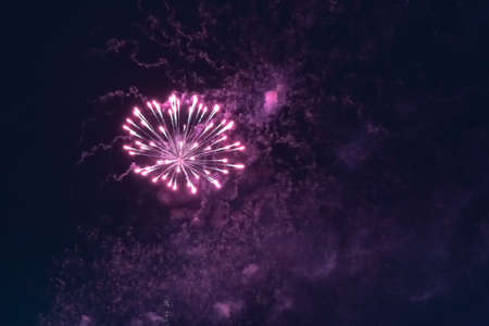 Beautiful inexpensive pink fireworks against the dark sky. With smoke. For any purpose.