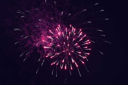 Beautiful inexpensive pink fireworks against the dark sky. With smoke. For any purpose.