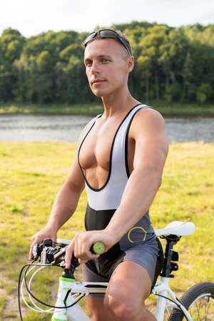 A man with a bicycle in nature. In the field, in the summer. For any purpose.の写真素材