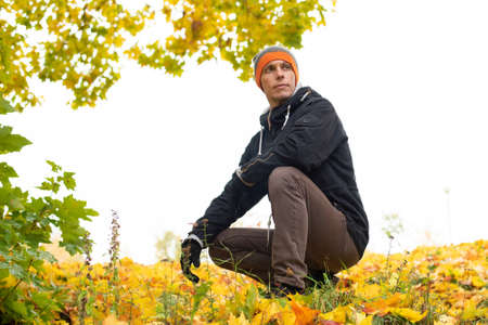 Man in the Indian summer. Sitting in yellow foliage. For any purpose.の写真素材