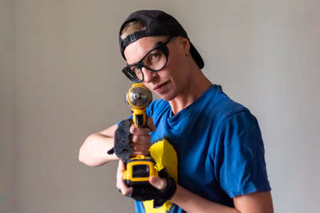 Woman builder with a drill in her hands For any purpose.
