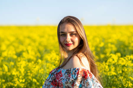 Minsk, Belarus - April 14, 2018 Girl in a dress in a rapeseed field. High quality photoのeditorial素材
