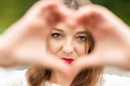 Portrait of woman with hand gesture.