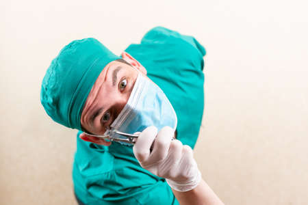 Doctor ENT, wearing a mask and glasses, with a device in his hands. High quality photoの写真素材