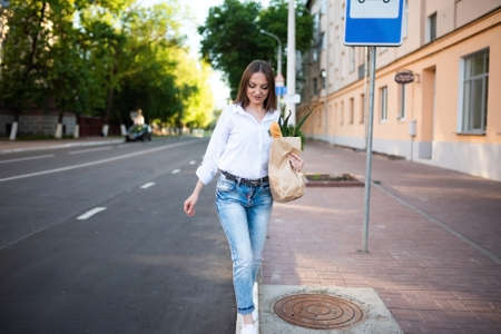 Beautiful girl with a paper bag with groceries. High quality photo