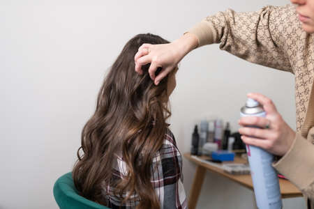 Stylist fixes curls with hairsprayの写真素材