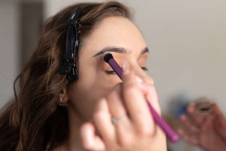 Stylist doing girl hair perm. high quality photo
