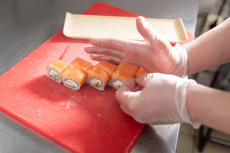 The chef prepares to serve sushi roll with salmon, cheese and cucumber. high quality photoの写真素材
