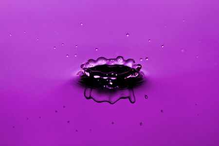 Water drop splashing on purple background