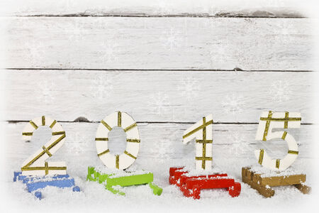 2015 number on a silver painted clapboard, each number set on painted sledsの写真素材