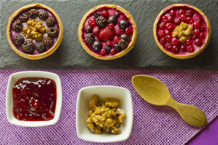 Autumn fruits cakes on a slate plate with ingredients on purple backgroundの写真素材