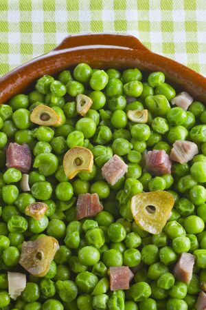 Peas with ham and garlic in an earthenware dishの写真素材