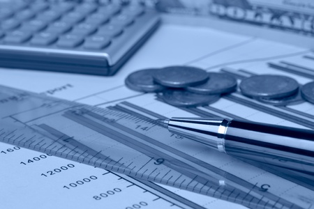 Business background in blues with money, ruler, calculator and pen.