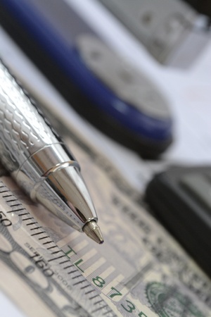 Business background with money, pen, calculator and stapler.の写真素材