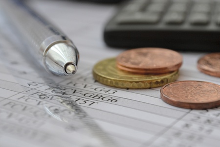 Business background with table, coins and pen.の写真素材