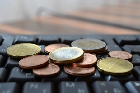 Coins on the keyboard - abstract business background.の写真素材