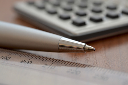 Business background with ruler, pen and calculator.