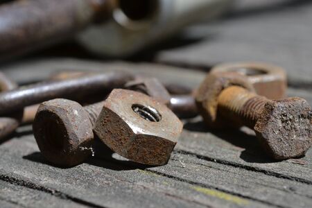 Rusty bolts and nuts on the wooden background.の写真素材
