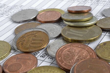 Financial background with different coins and table.の写真素材