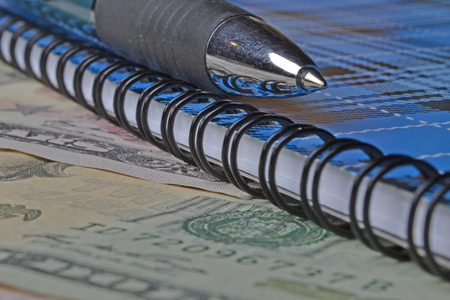 Financial background with money, notebook and pen.の写真素材