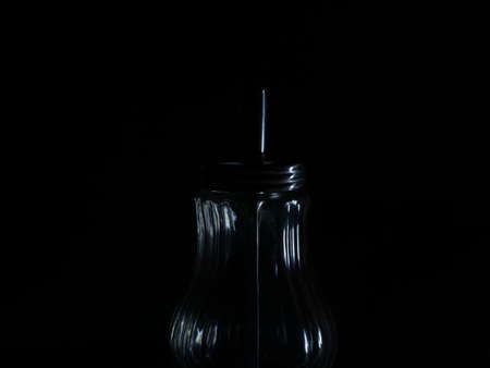 Empty sugar dispenser in dark room. Low key studio shot. Dark mood picture.の写真素材