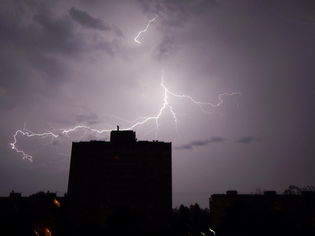 Lightning and thunder at night in the city it's raining