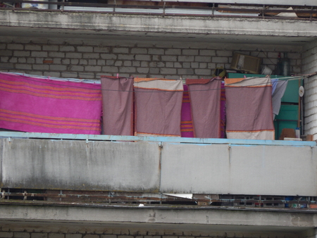 The washed laundry is dried on the balcony of the houseのeditorial素材