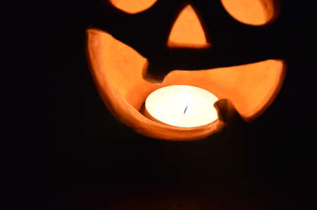 Lighted pumpkin-shaped candle for halloween the burningの写真素材