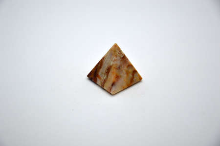Figure of a pyramid made of stone on a white the backgroundの写真素材