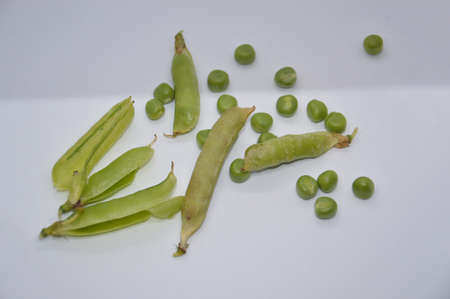 Young and ripe green peas on a the white background