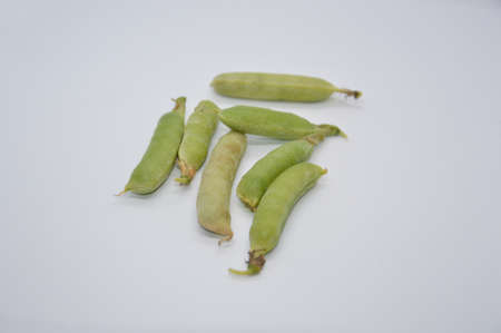 Young and ripe green peas on a the white background