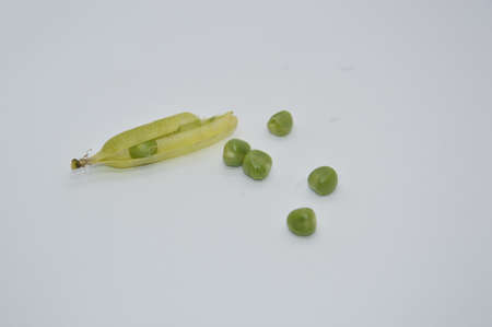 Young and ripe green peas on a the white backgroundの写真素材