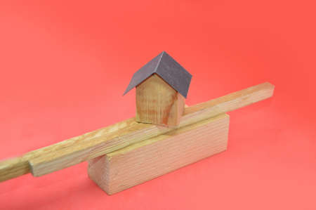 Architectural composition of the modules of the house surrounded by wooden figures on a the red backgroundの写真素材