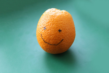 Smiling orange on a green backgroundの写真素材