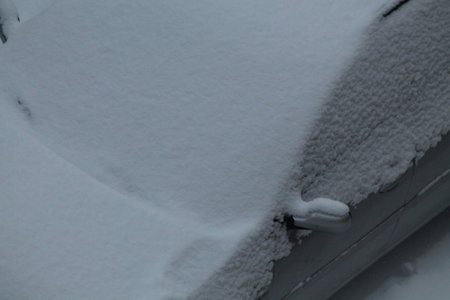 Passenger cars covered with snow on a the streetの写真素材