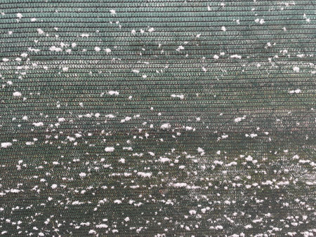 A peaceful winter image depicting a garden fence topped with a layer of fresh snow.