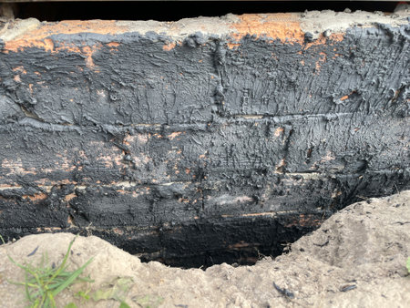 Close-up of bitumen rubber mastic being applied to a construction surface for waterproofing.の写真素材