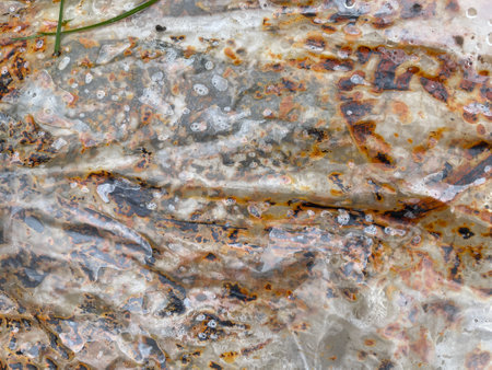 Close-up view of rust stains and spots on a worn plastic or vinyl sheet.の写真素材