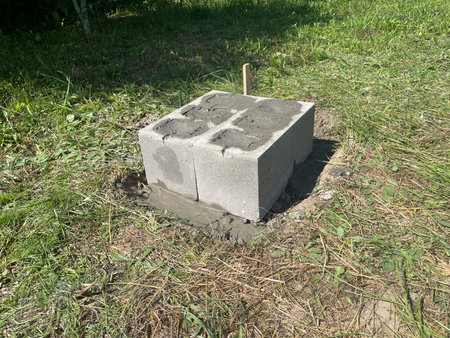 A basic foundation structure built using concrete cinder blocks, laid directly on compacted ground or gravel base.の写真素材