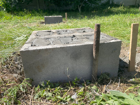 A basic foundation structure built using concrete cinder blocks, laid directly on compacted ground or gravel base.の写真素材