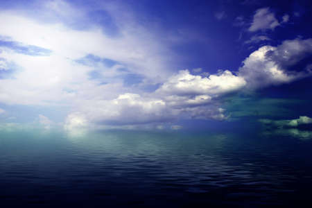 cloudy blue sky leaving for horizon above a blue surface of the seaの写真素材