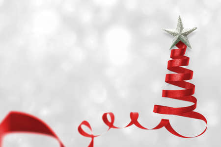 Christmas tree made of red satin ribbon scroll with silver star isolated on white snow background with clipping path for winter xmas holiday greeting card design arts elementの写真素材